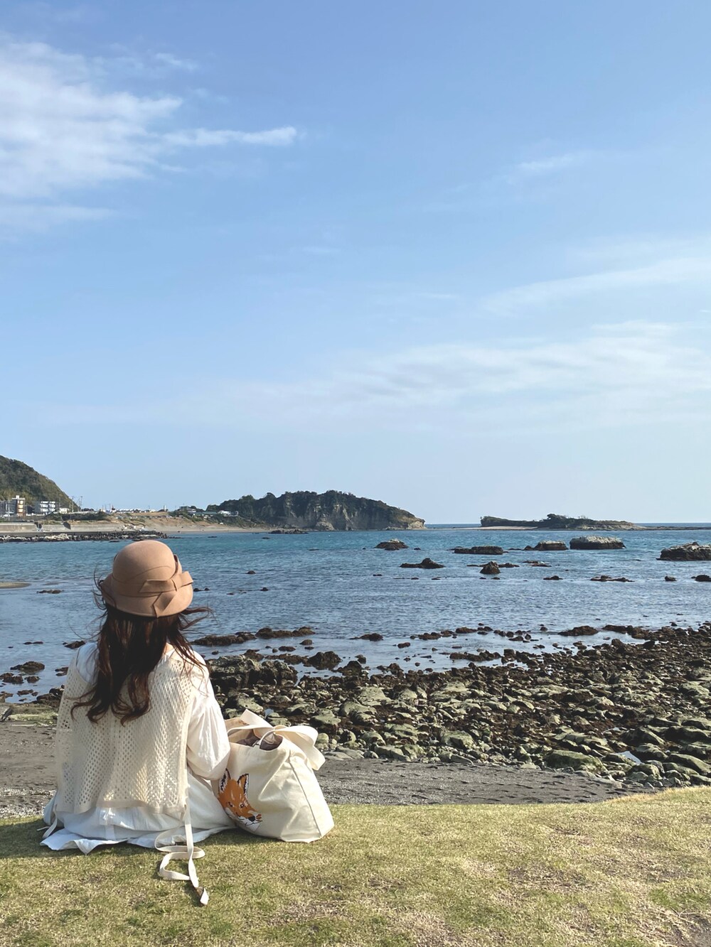 ベージュ系のベスト、ホワイト系のトートバッグ、ホワイト系のワンピースを着用したレディースの秋コーディネートの3枚目の写真