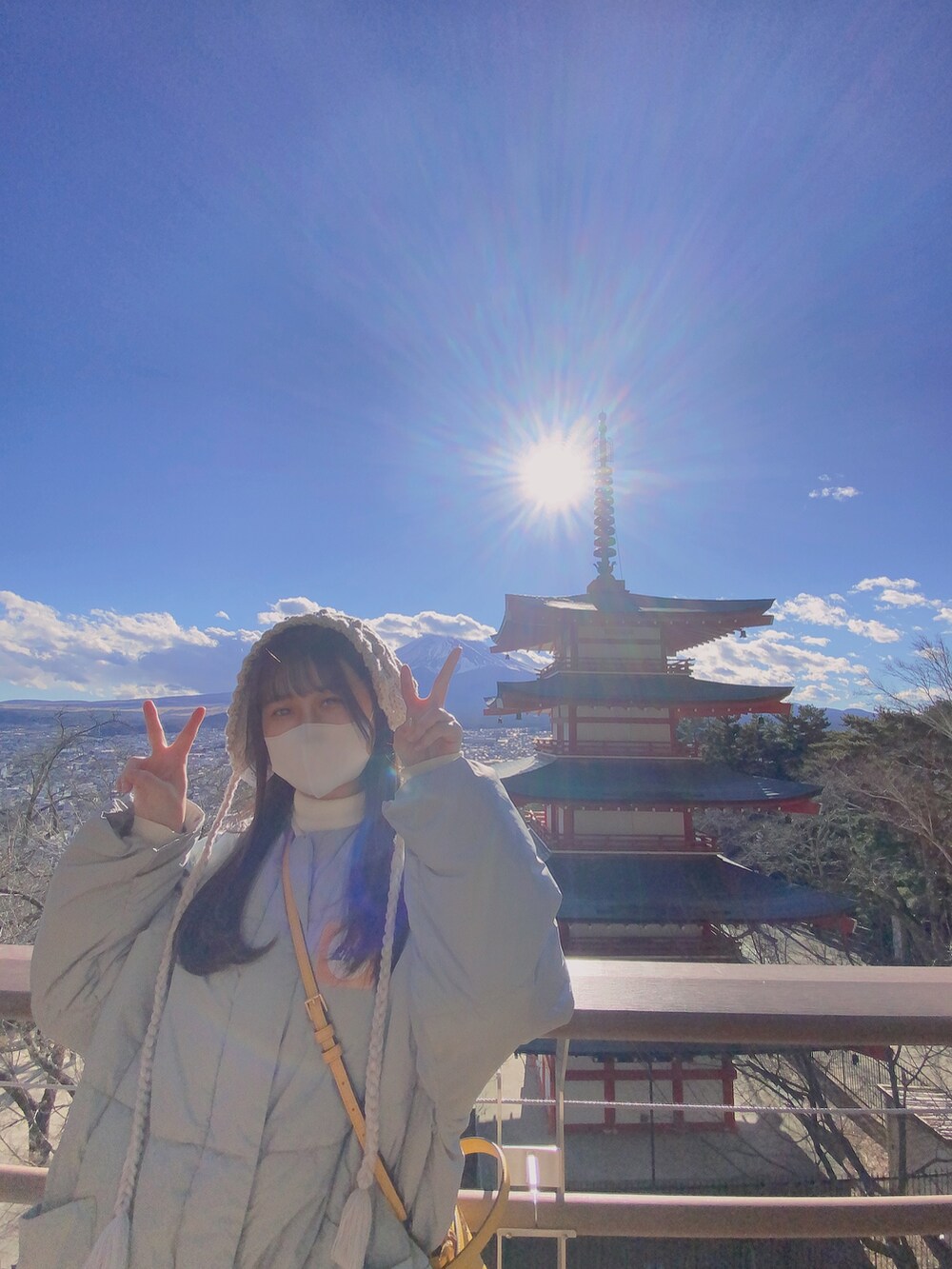 ベージュ系のブーツ、グレー系のダウンジャケット/コート、イエロー系のショルダーバッグを着用したレディースの冬コーディネートの2枚目の写真