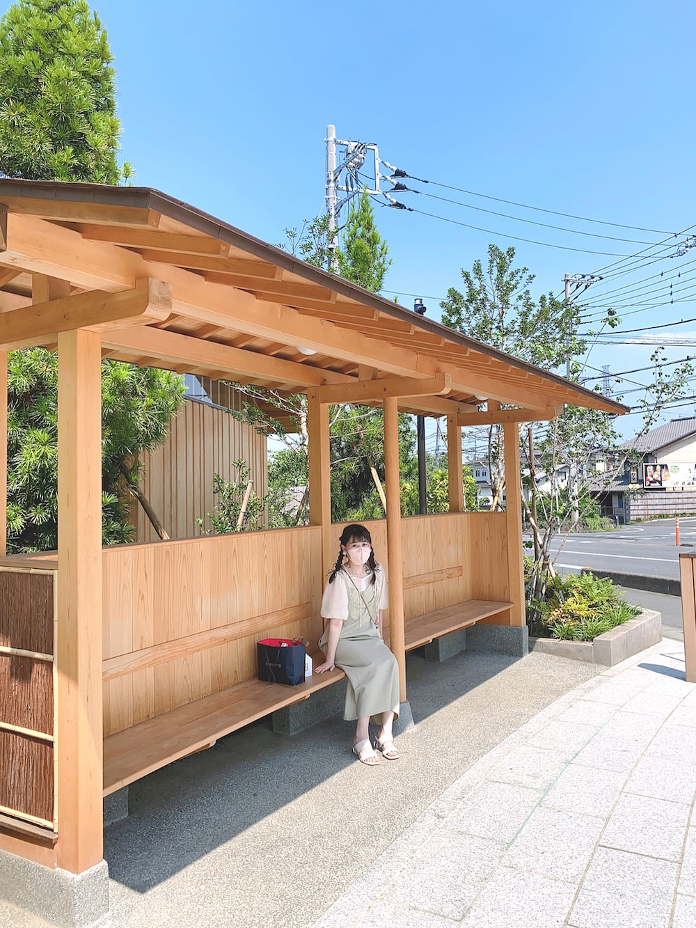 ベージュ系のワンピース、ホワイト系のシャツ/ブラウス、ホワイト系のショルダーバッグを着用したレディースの夏コーディネートの2枚目の写真