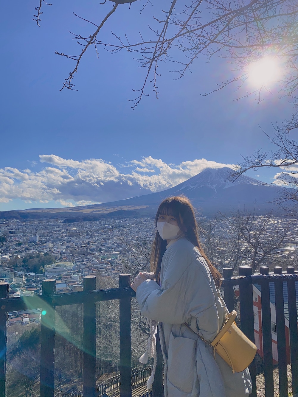 ベージュ系のブーツ、グレー系のダウンジャケット/コート、イエロー系のショルダーバッグを着用したレディースの冬コーディネートの3枚目の写真