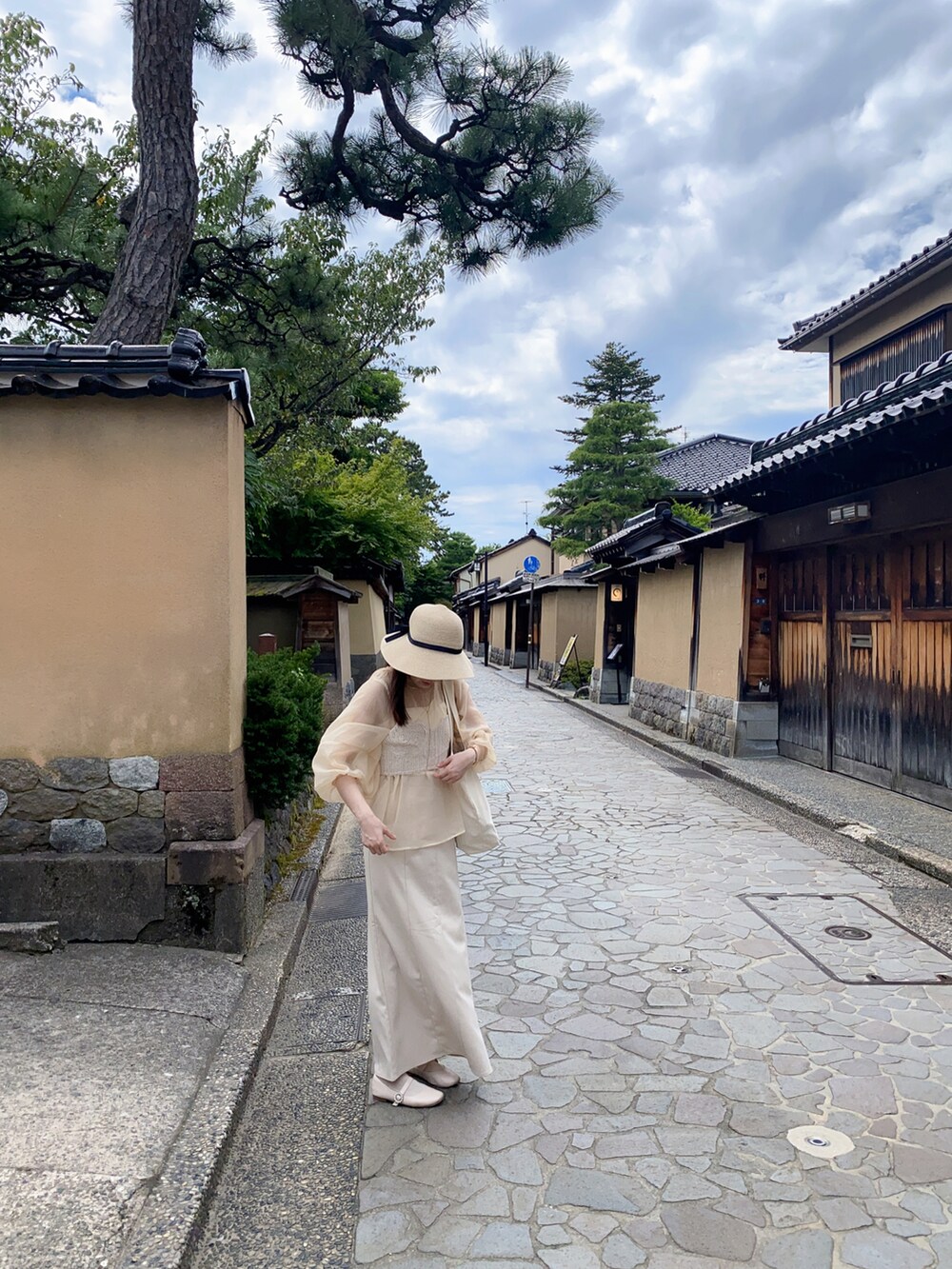 ホワイト系のキャミソール、ホワイト系のスカート、ホワイト系のトートバッグを着用したレディースの夏コーディネートの2枚目の写真