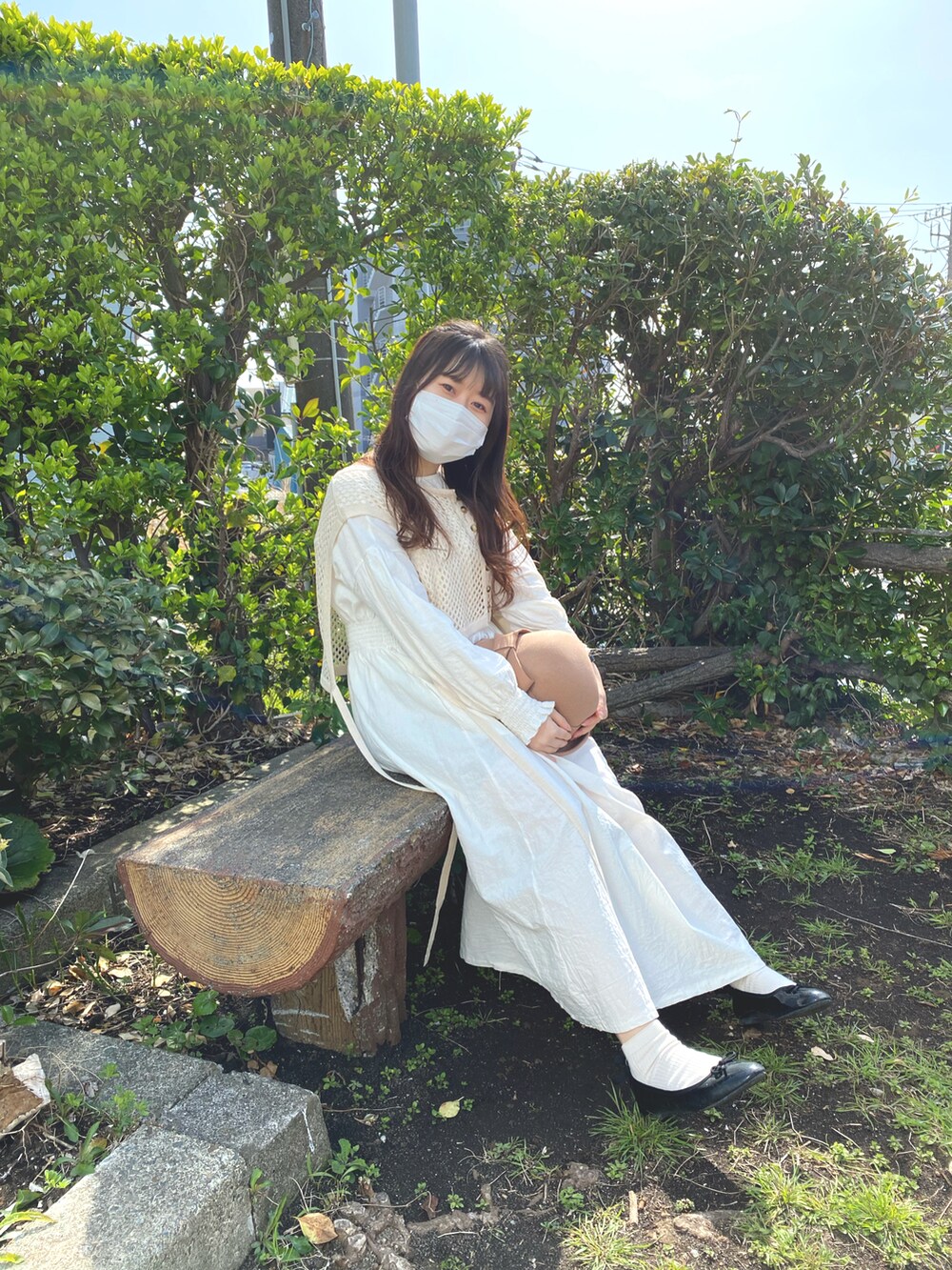 ベージュ系のベスト、ホワイト系のトートバッグ、ホワイト系のワンピースを着用したレディースの秋コーディネートの2枚目の写真