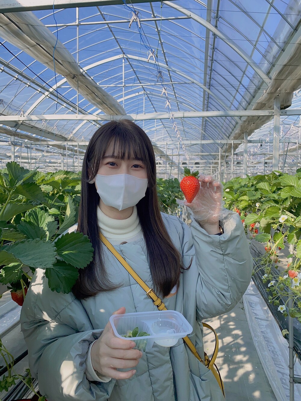 ベージュ系のブーツ、グレー系のダウンジャケット/コート、イエロー系のショルダーバッグを着用したレディースの冬コーディネートの4枚目の写真