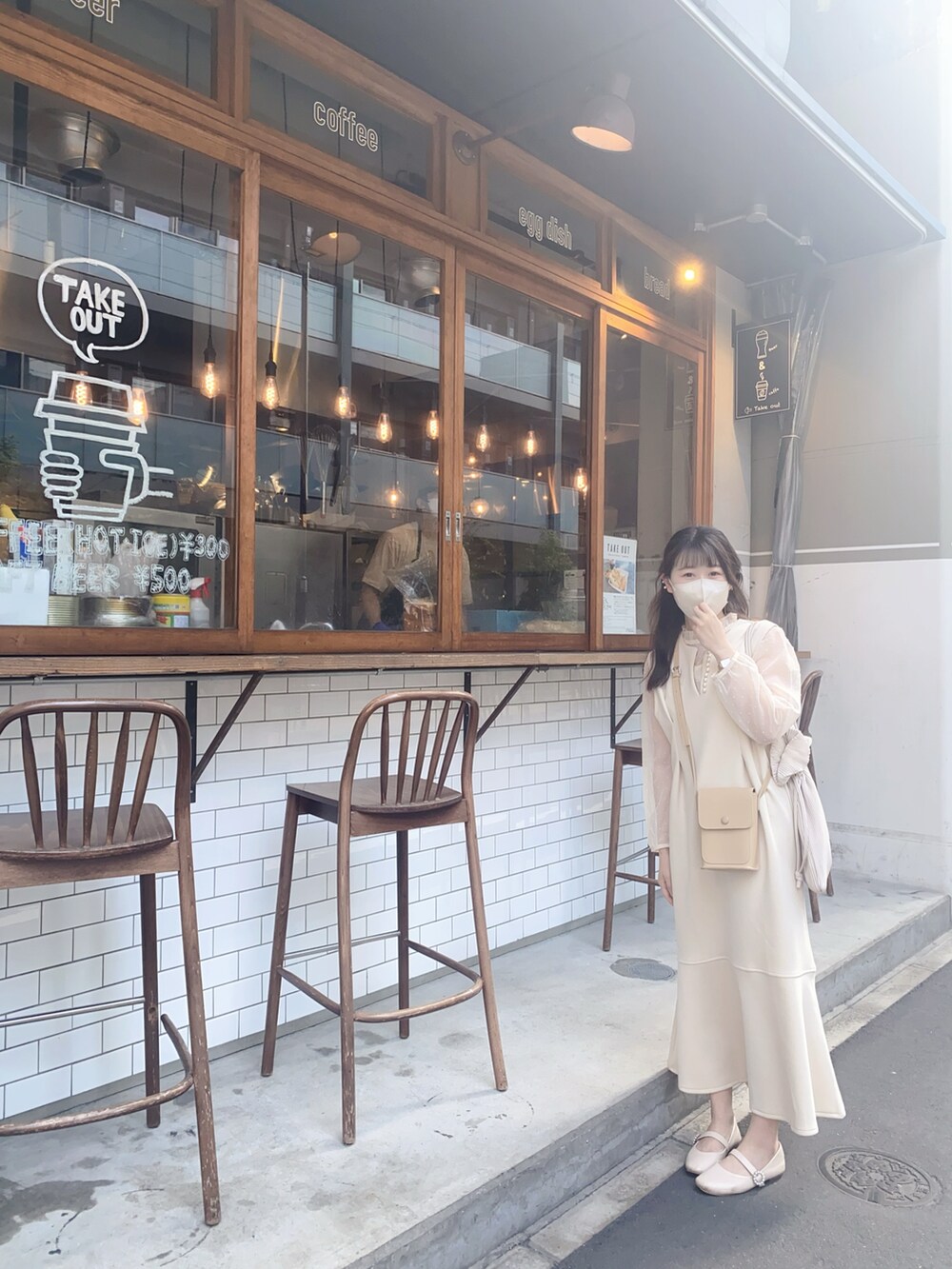 ホワイト系のジャンパースカートを着用したレディースの秋コーディネートの2枚目の写真