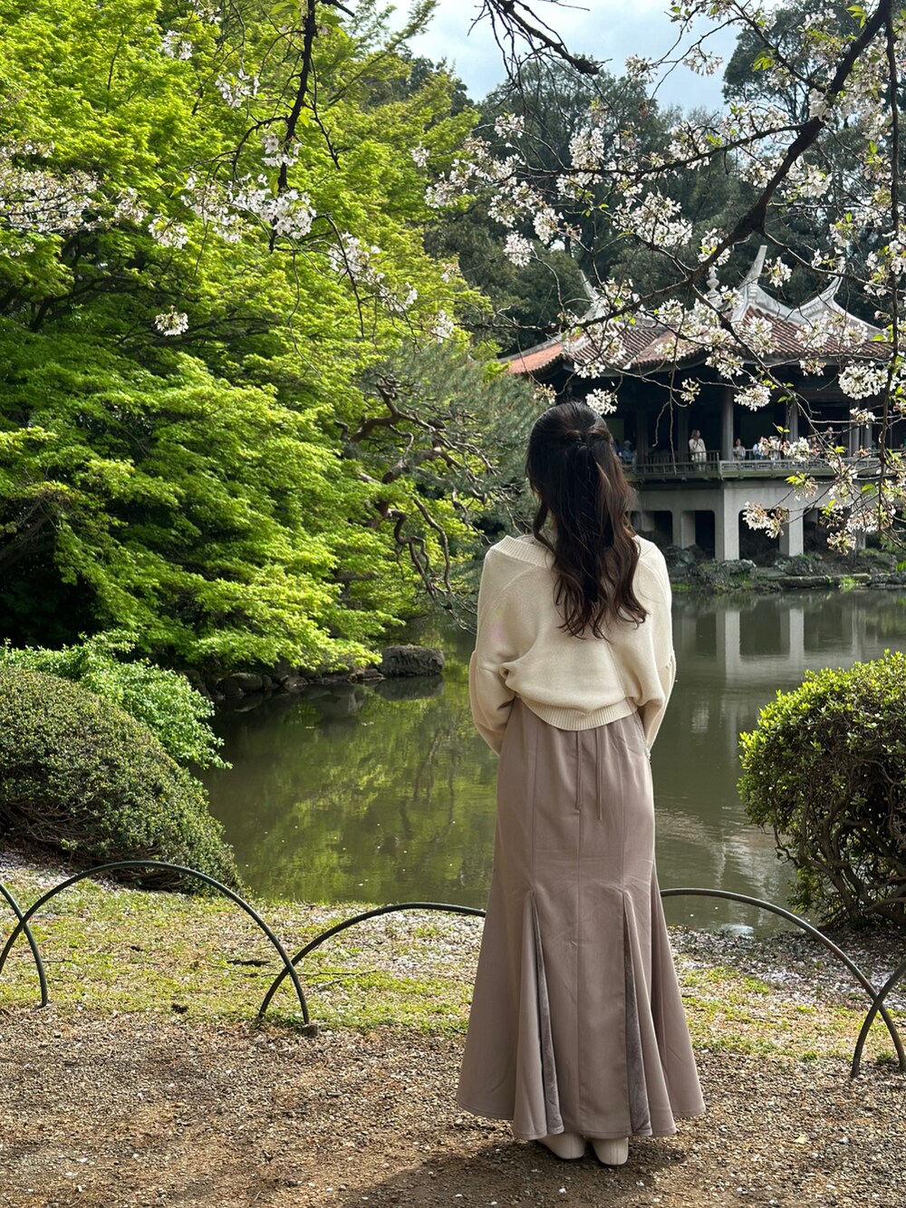 ホワイト系のトップス、ホワイト系のカーディガン/ボレロ、ブラウン系のドレスを着用したレディースの春コーディネートの2枚目の写真