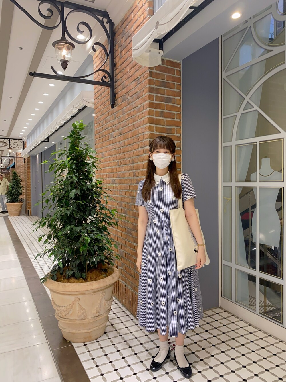 ホワイト系のトートバッグ、ブルー系のワンピース、ブラック系のレインシューズを着用したレディースの夏コーディネートの2枚目の写真