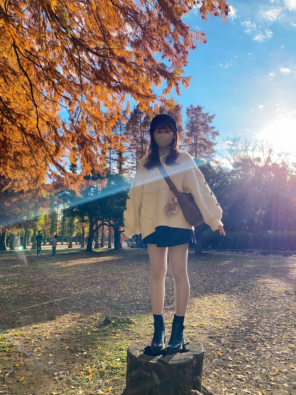 ホワイト系のニット/セーター、ブラック系のブーツ、ブラウン系のショルダーバッグを着用したレディースの冬コーディネートの2枚目の写真