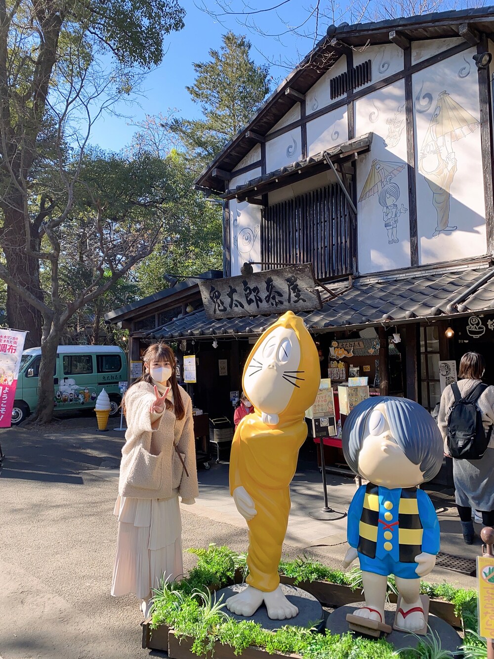 ベージュ系のノーカラーコート、ホワイト系のスカート、ホワイト系のカーディガン/ボレロを着用したレディースの冬コーディネートの3枚目の写真