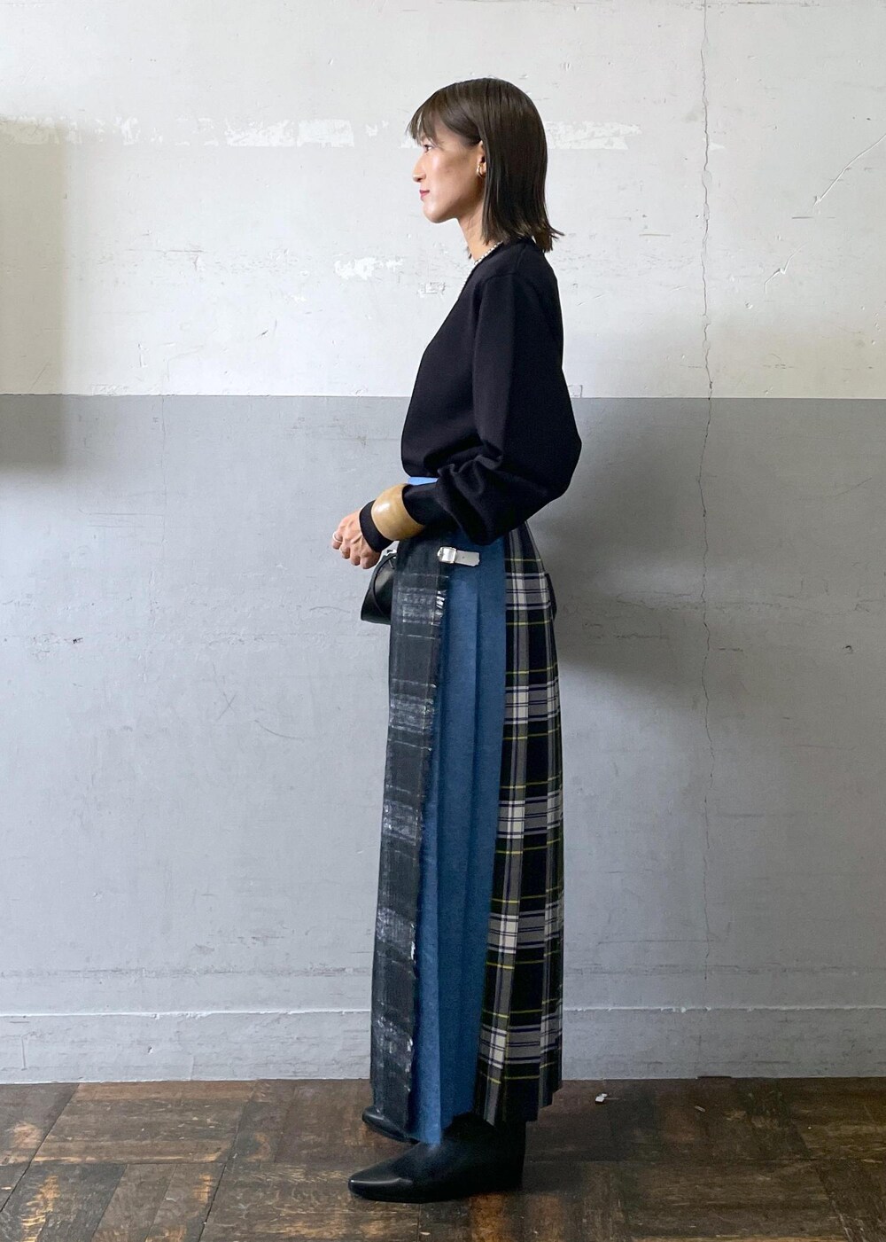 ブラック系のショルダーバッグ、ブラック系のブーツ、ブラック系のスカートを着用したレディースの秋コーディネートの3枚目の写真