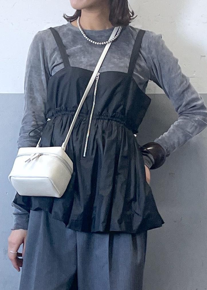 ブラック系のパンプス、グレー系のスラックス、ブラック系のTシャツ/カットソーを着用したレディースの冬コーディネートの3枚目の写真