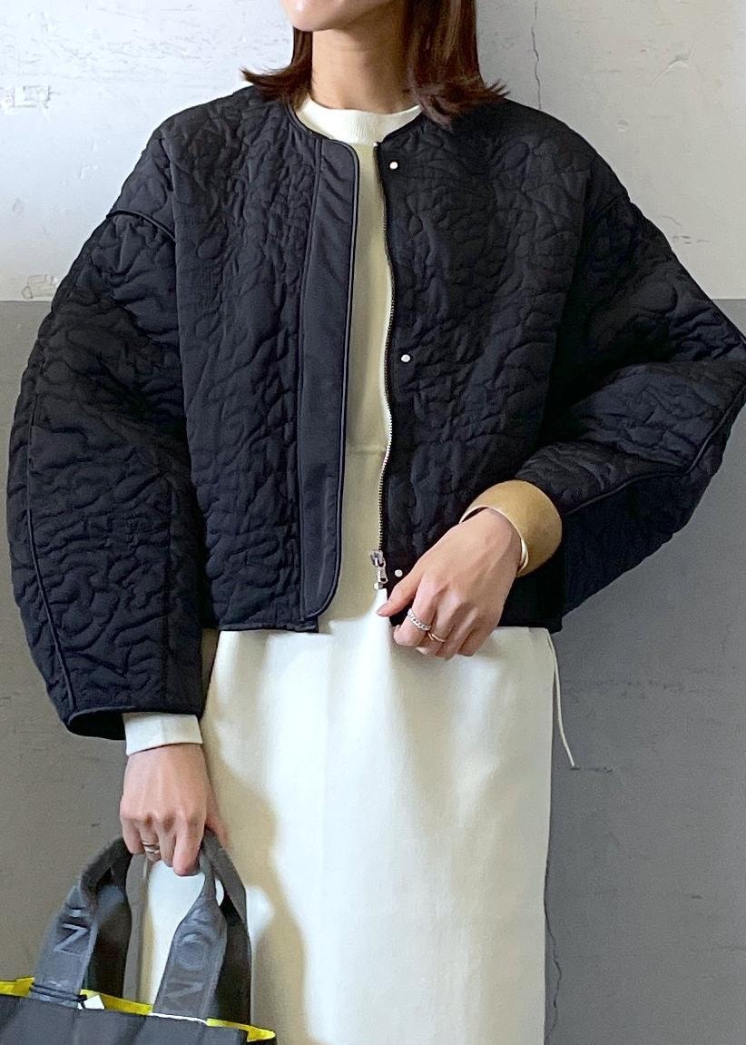 ホワイト系のワンピース、ブラック系のブルゾン、グレー系のハンドバッグを着用したレディースの冬コーディネートの5枚目の写真