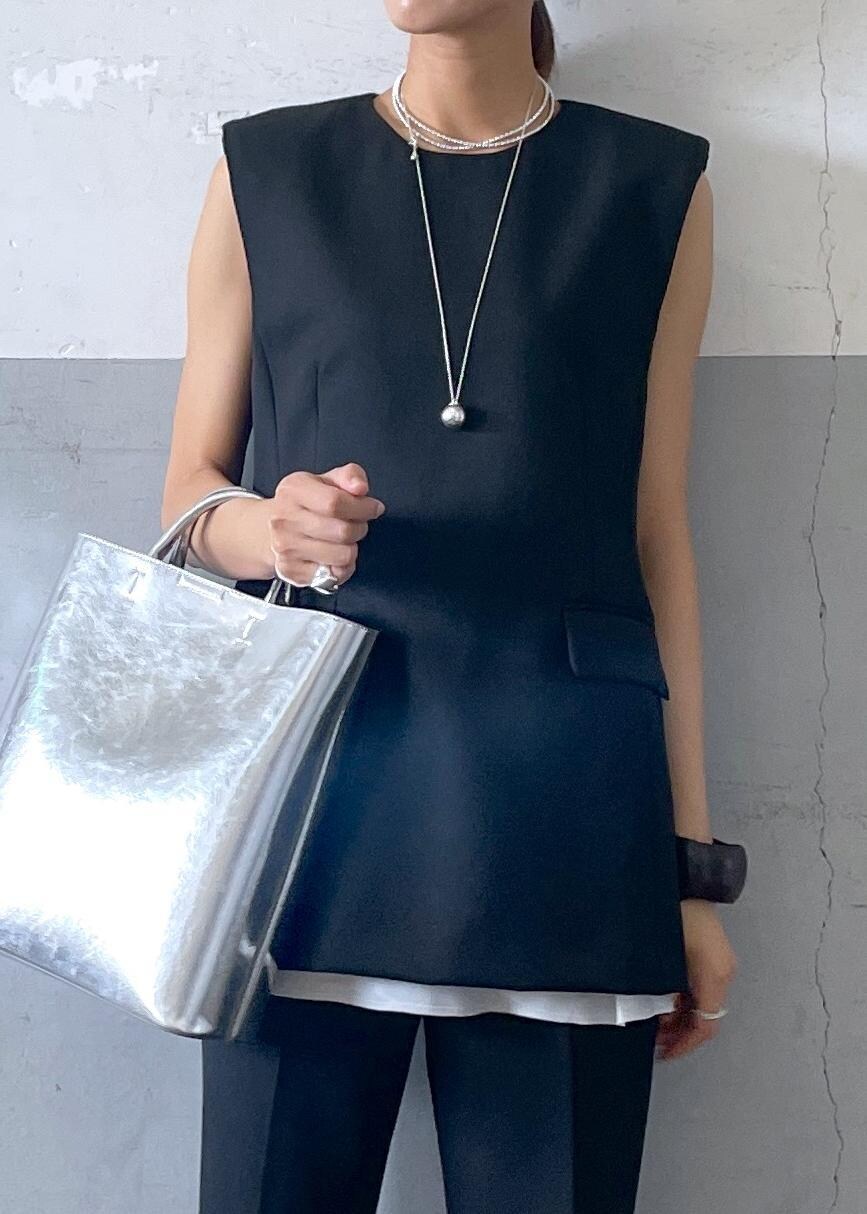 シルバー系のバレエシューズ、シルバー系のトートバッグ、ブラック系のベストを着用したレディースの夏コーディネートの5枚目の写真