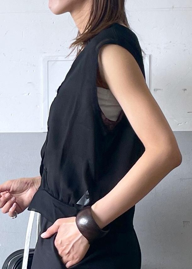 ブラック系のボストンバッグ、ホワイト系のパンプス、ブラック系のスラックスを着用したレディースの夏コーディネートの5枚目の写真