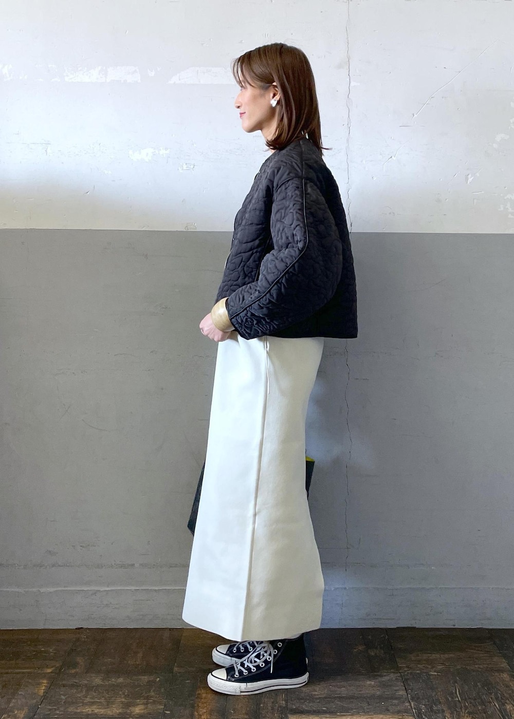 ホワイト系のワンピース、ブラック系のブルゾン、グレー系のハンドバッグを着用したレディースの冬コーディネートの3枚目の写真