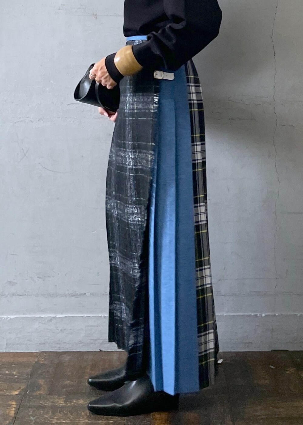 ブラック系のショルダーバッグ、ブラック系のブーツ、ブラック系のスカートを着用したレディースの秋コーディネートの8枚目の写真