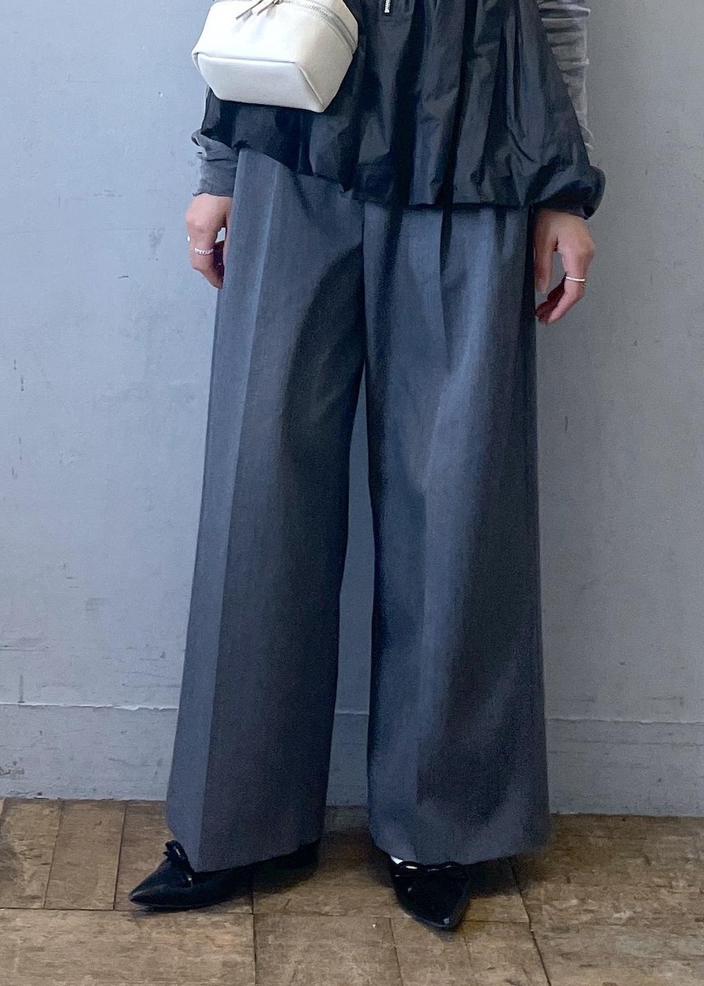 ブラック系のパンプス、グレー系のスラックス、ブラック系のTシャツ/カットソーを着用したレディースの冬コーディネートの6枚目の写真