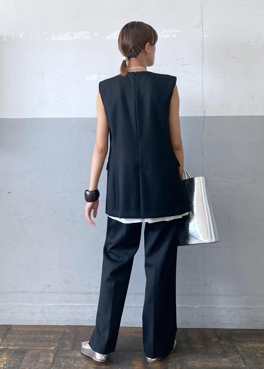 シルバー系のバレエシューズ、シルバー系のトートバッグ、ブラック系のベストを着用したレディースの夏コーディネートの4枚目の写真