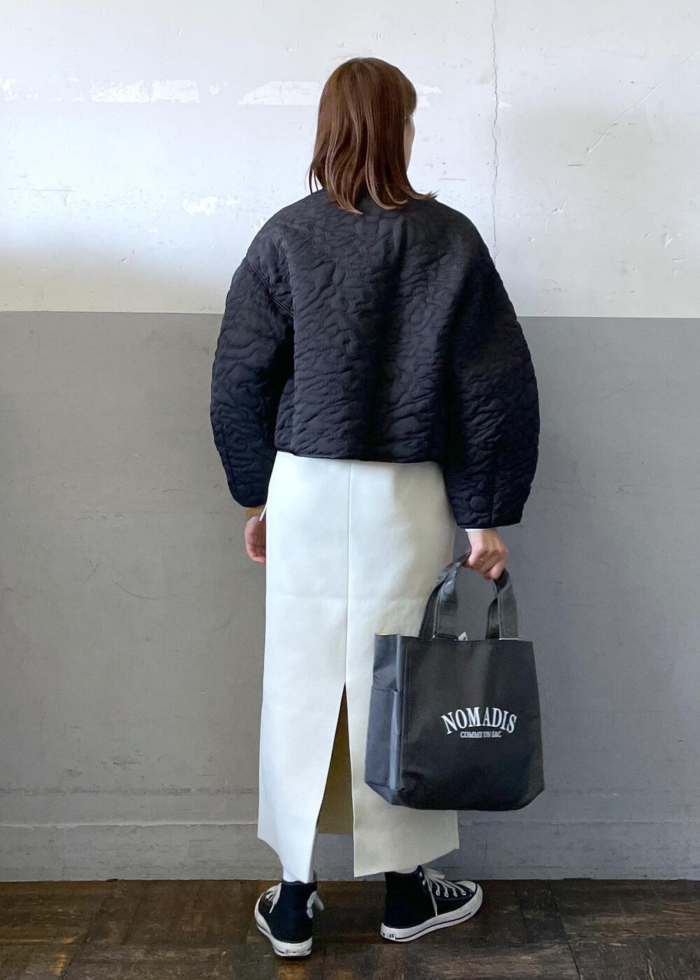 ホワイト系のワンピース、ブラック系のブルゾン、グレー系のハンドバッグを着用したレディースの冬コーディネートの4枚目の写真