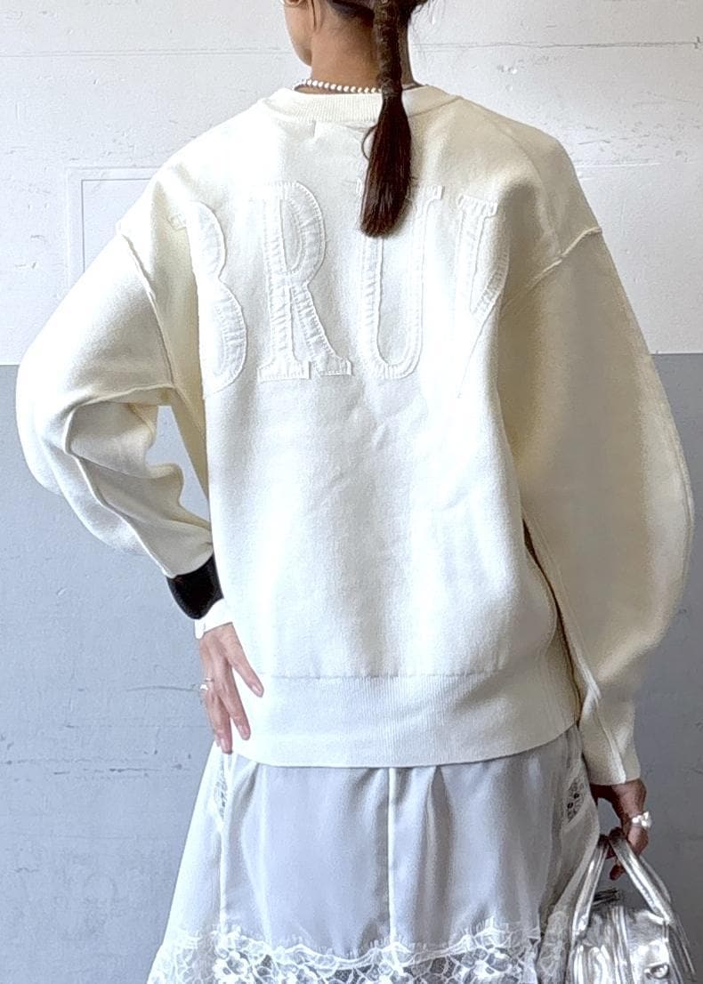 シルバー系のショルダーバッグ、ホワイト系のニット/セーター、ブラック系のブーツを着用したレディースの秋コーディネートの6枚目の写真