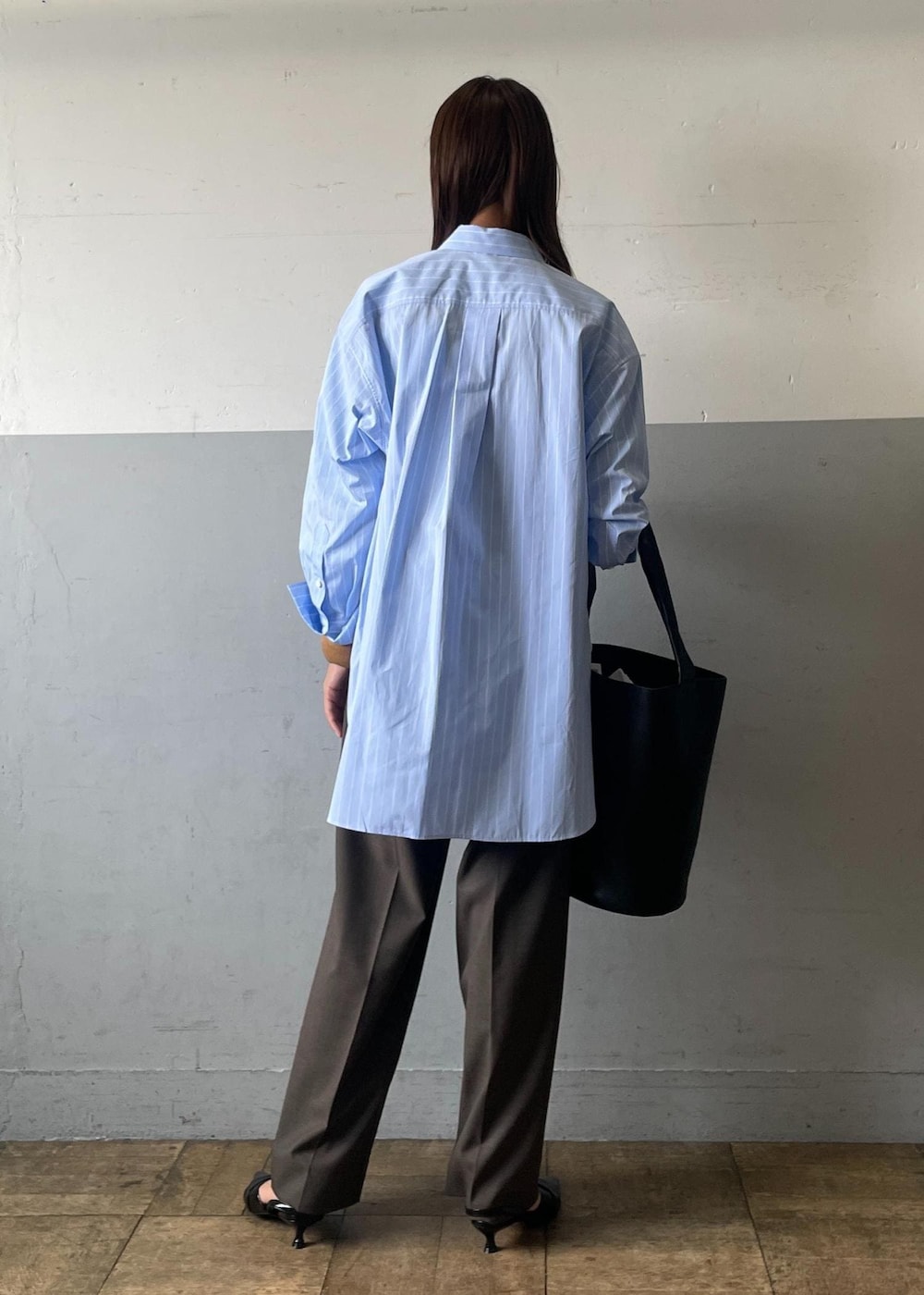 ブラック系のサンダル、ブラック系のショルダーバッグ、グレー系のスラックスを着用したレディースの夏コーディネートの3枚目の写真