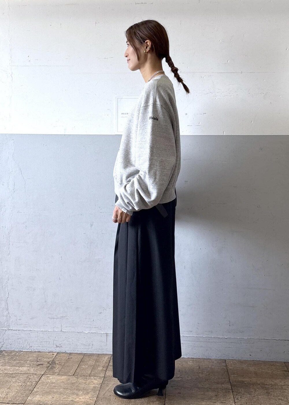 ブラック系のショルダーバッグ、ブラック系のブーツ、ブラック系のスカートを着用したレディースの秋コーディネートの2枚目の写真