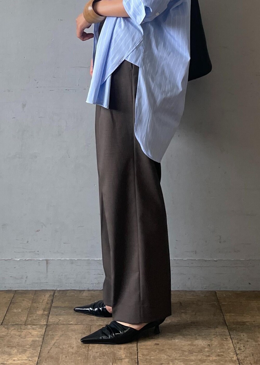 ブラック系のサンダル、ブラック系のショルダーバッグ、グレー系のスラックスを着用したレディースの夏コーディネートの8枚目の写真