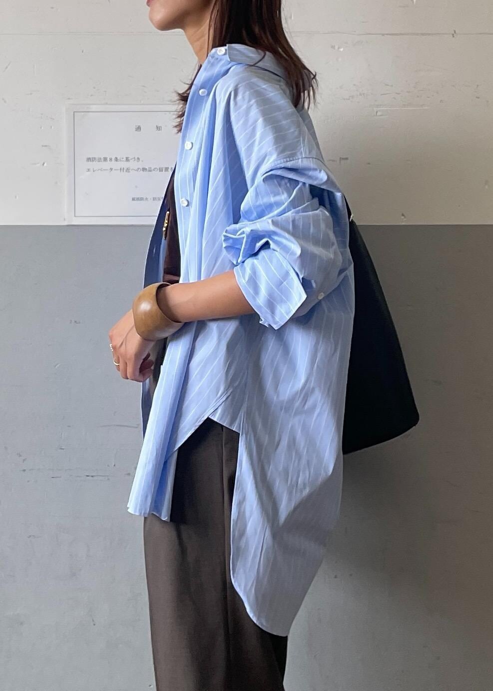 ブラック系のサンダル、ブラック系のショルダーバッグ、グレー系のスラックスを着用したレディースの夏コーディネートの5枚目の写真