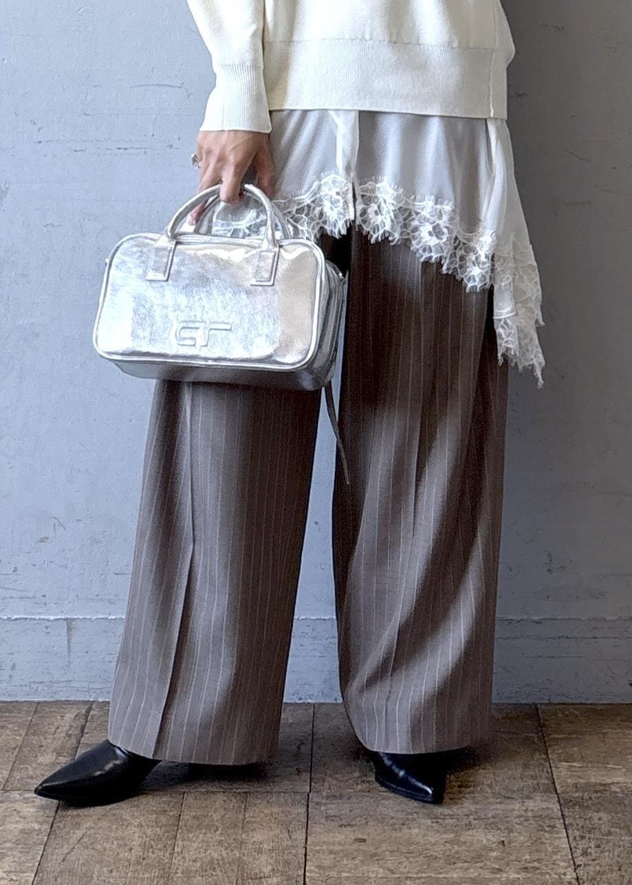 シルバー系のショルダーバッグ、ホワイト系のニット/セーター、ブラック系のブーツを着用したレディースの秋コーディネートの7枚目の写真