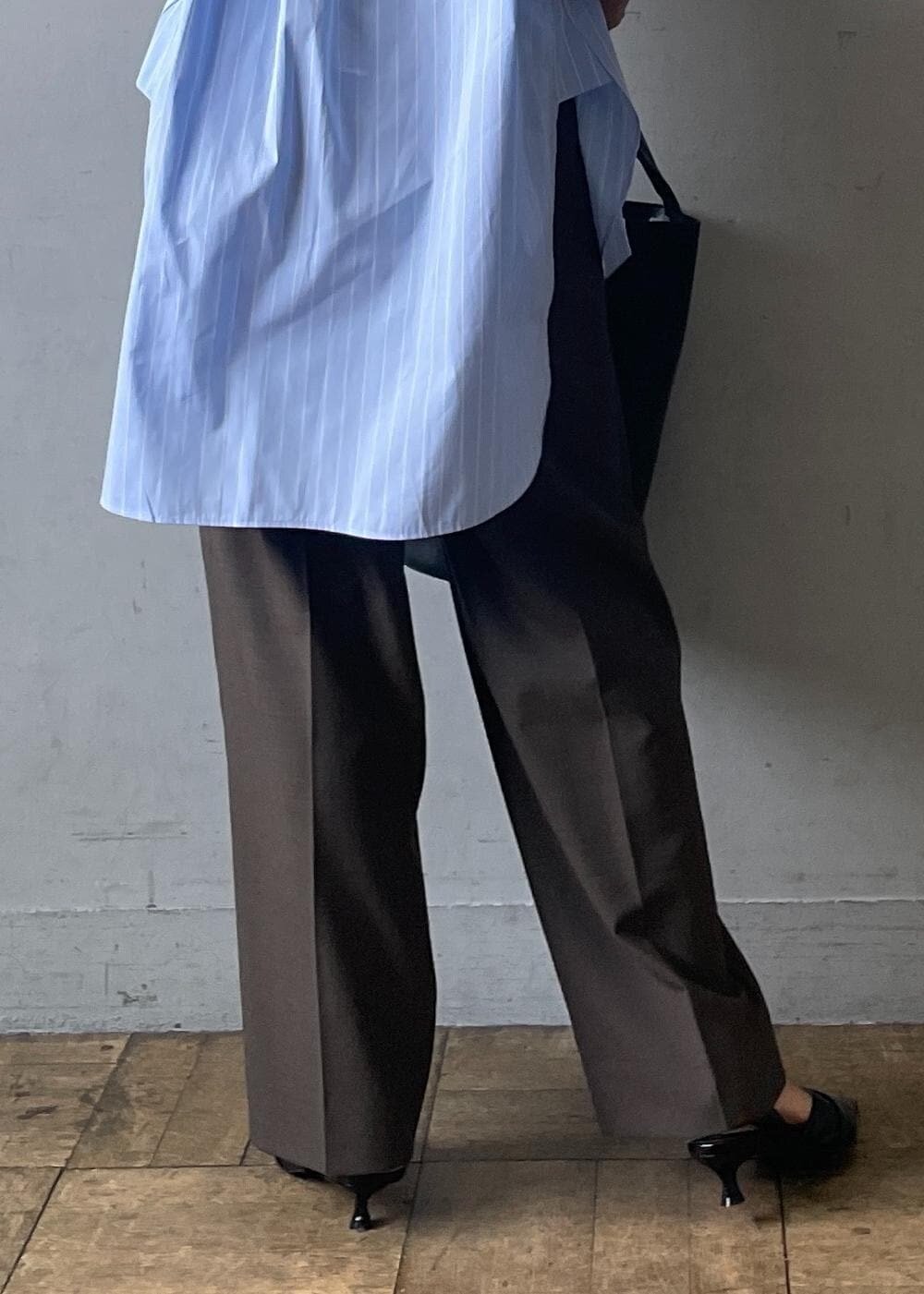 ブラック系のサンダル、ブラック系のショルダーバッグ、グレー系のスラックスを着用したレディースの夏コーディネートの9枚目の写真