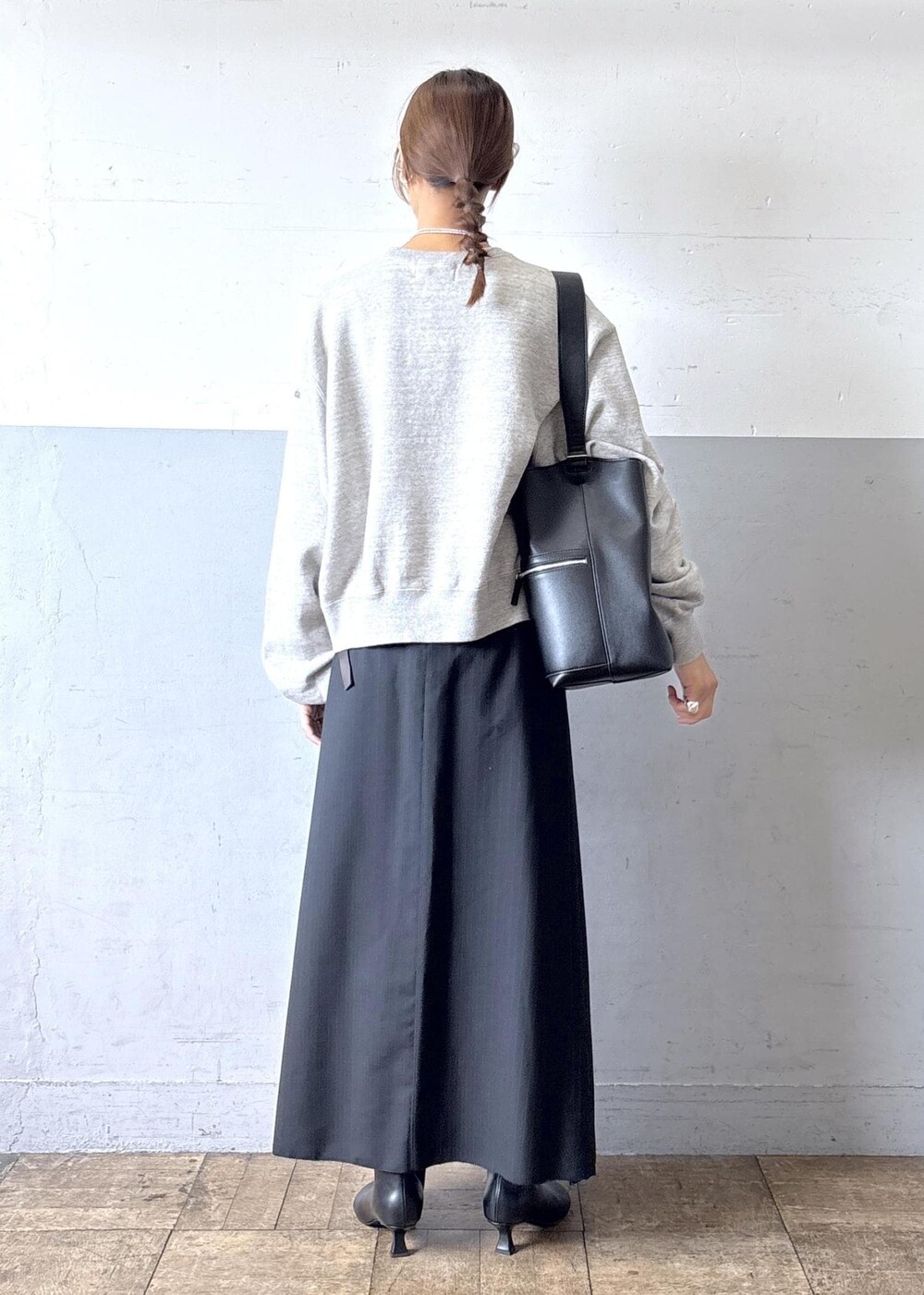 ブラック系のショルダーバッグ、ブラック系のブーツ、ブラック系のスカートを着用したレディースの秋コーディネートの3枚目の写真