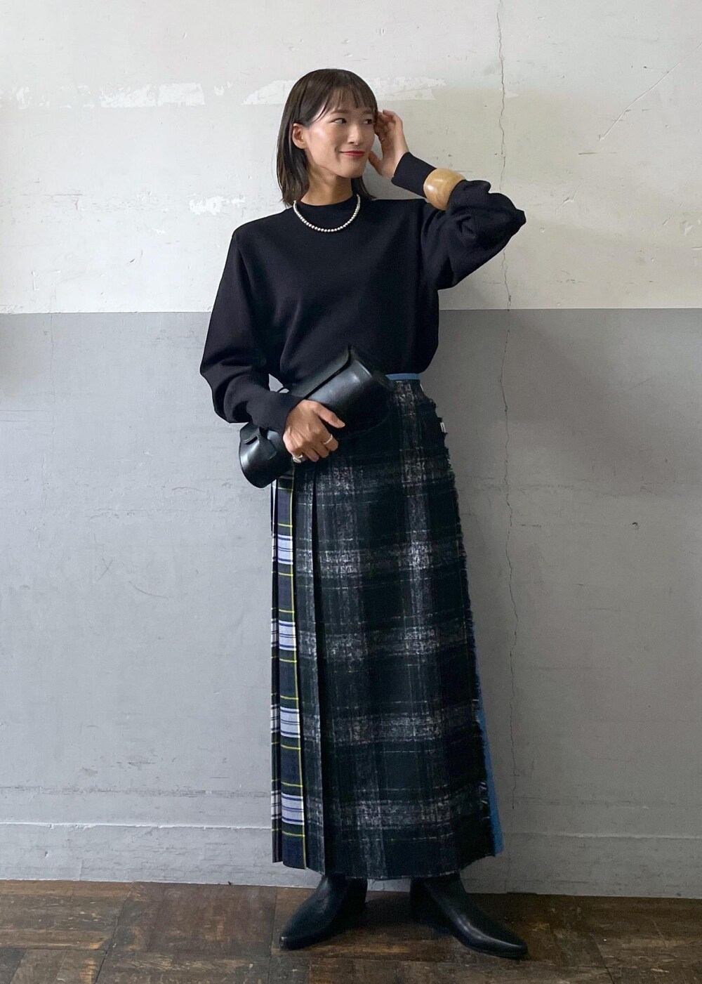 ブラック系のショルダーバッグ、ブラック系のブーツ、ブラック系のスカートを着用したレディースの秋コーディネートの2枚目の写真