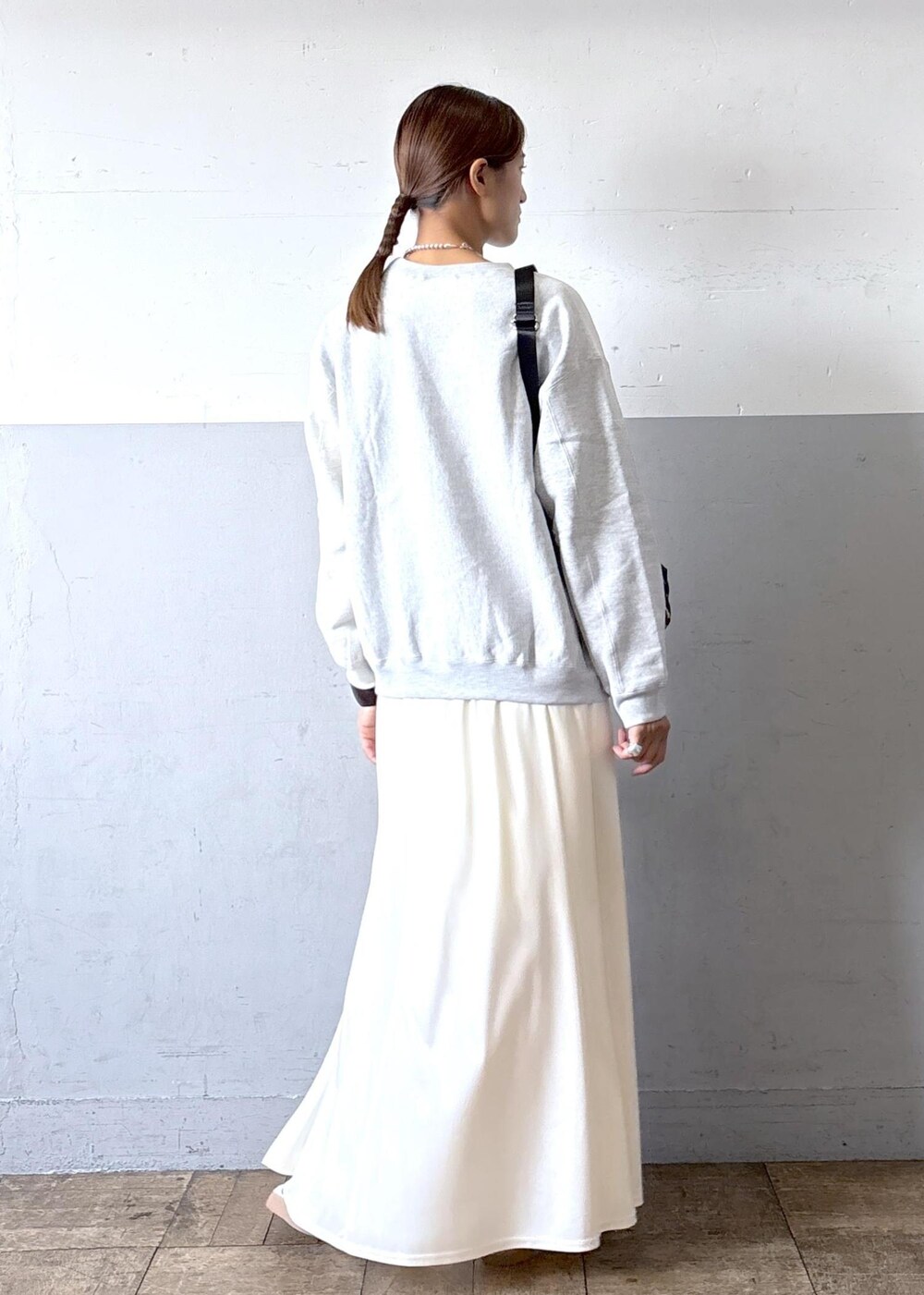 ベージュ系のショルダーバッグ、ホワイト系のスニーカー、ホワイト系のスカートを着用したレディースの秋コーディネートの3枚目の写真