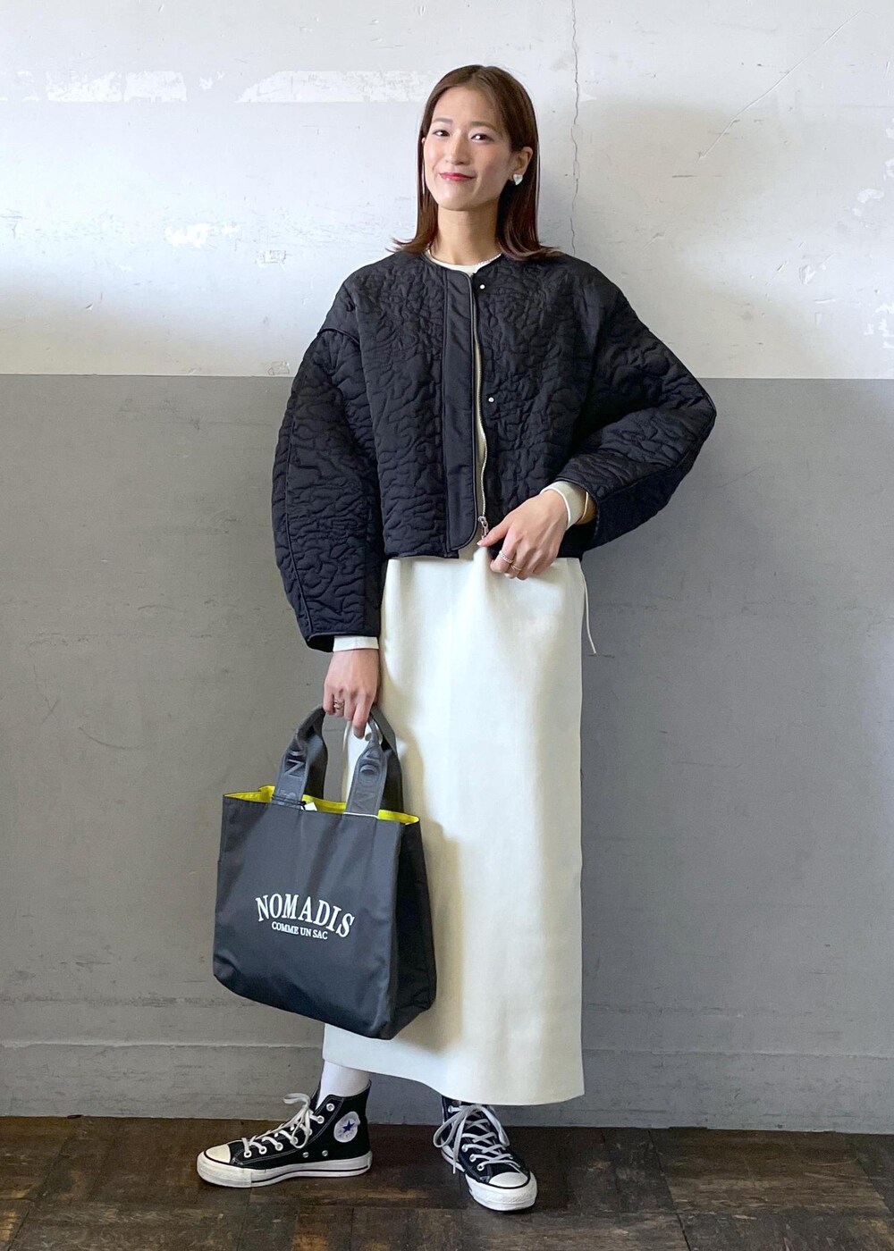 ホワイト系のワンピース、ブラック系のブルゾン、グレー系のハンドバッグを着用したレディースの冬コーディネートの2枚目の写真