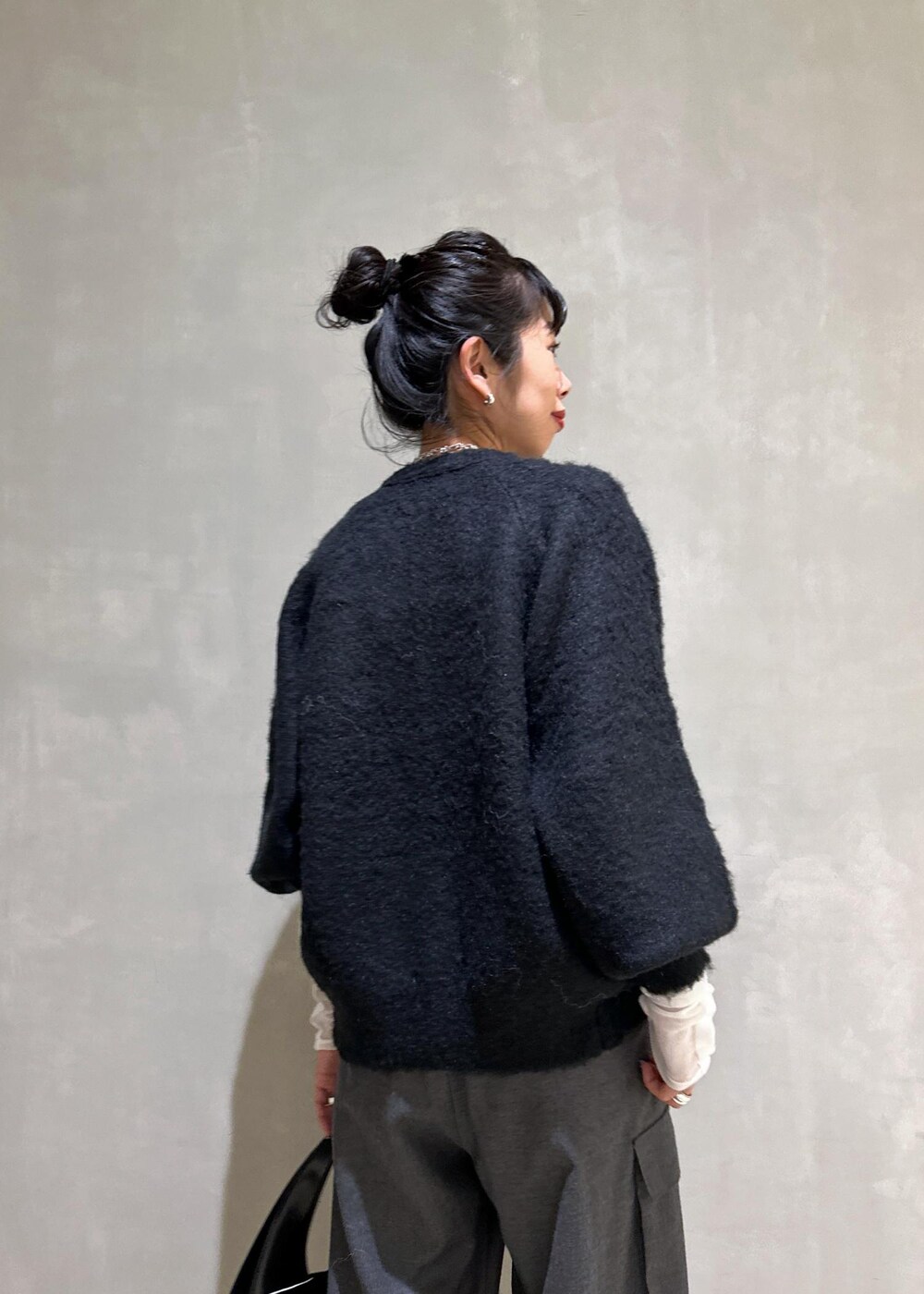 ブラック系のカーディガン/ボレロ、ブラック系のハンドバッグ、ホワイト系のTシャツ/カットソーを着用したレディースの秋コーディネートの8枚目の写真