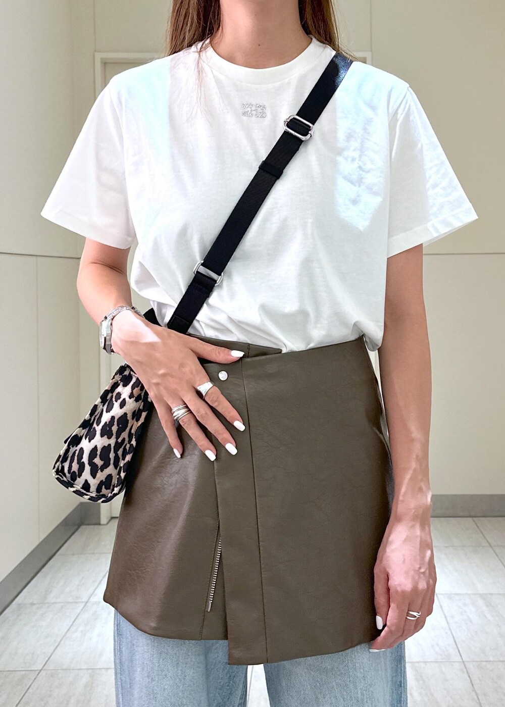 ベージュ系のトートバッグ、ブラウン系のスカート、ホワイト系のTシャツ/カットソーを着用したレディースの夏コーディネートの4枚目の写真