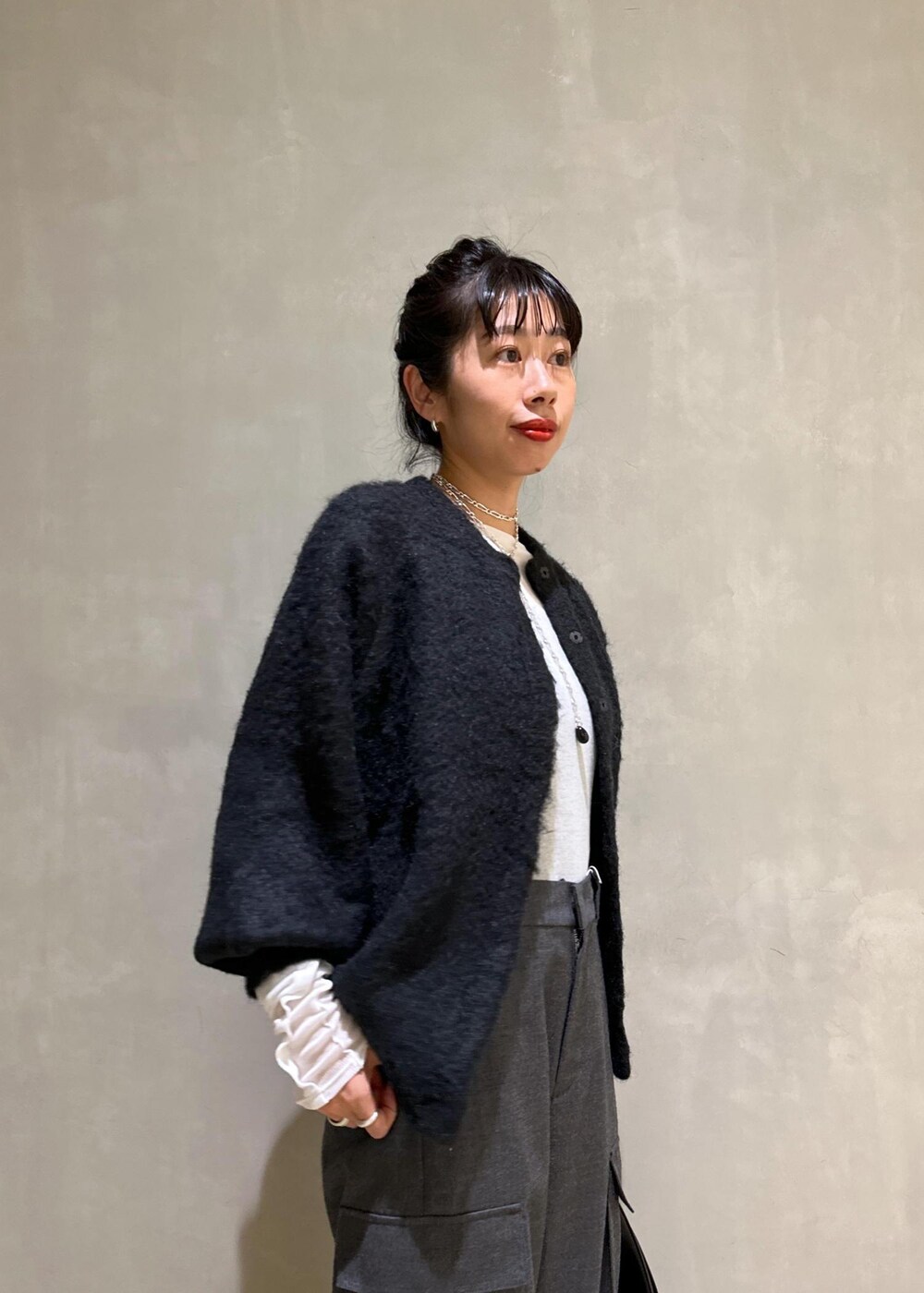 ブラック系のカーディガン/ボレロ、ブラック系のハンドバッグ、ホワイト系のTシャツ/カットソーを着用したレディースの秋コーディネートの7枚目の写真