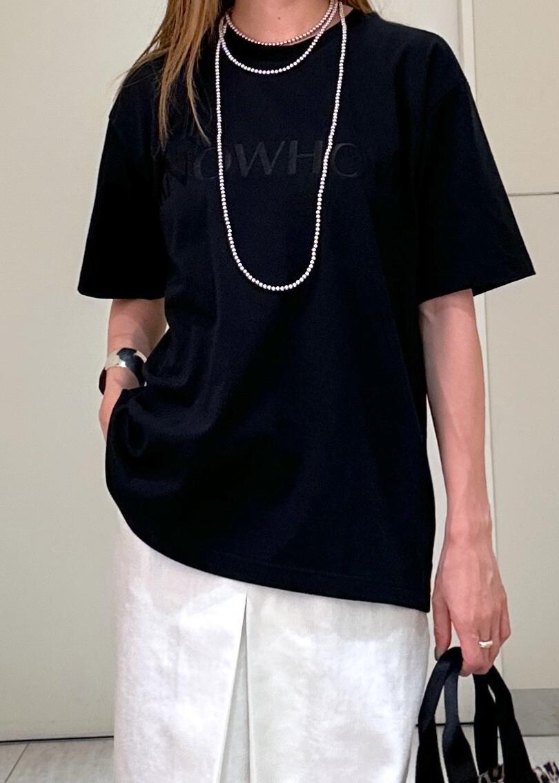 ブラウン系のショルダーバッグ、ホワイト系のスカート、ブラック系のTシャツ/カットソーを着用したレディースの夏コーディネートの5枚目の写真