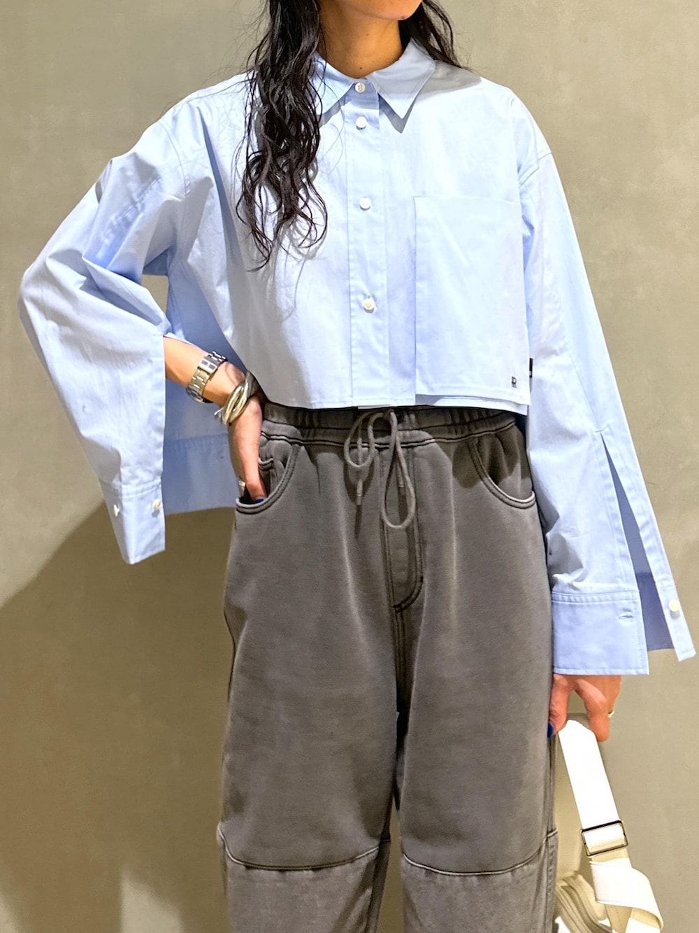 ブルー系のシャツ/ブラウス、ホワイト系のショルダーバッグを着用したレディースの春コーディネートの6枚目の写真