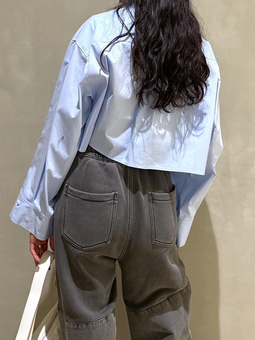 ブルー系のシャツ/ブラウス、ホワイト系のショルダーバッグを着用したレディースの春コーディネートの8枚目の写真