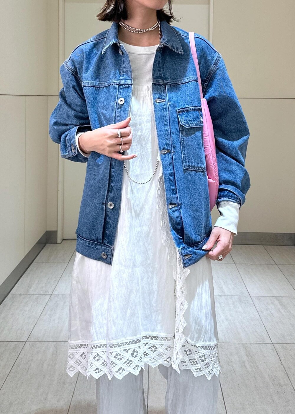 ホワイト系のその他パンツ、ピンク系のショルダーバッグ、ブルー系のデニムジャケットを着用したレディースの冬コーディネートの5枚目の写真
