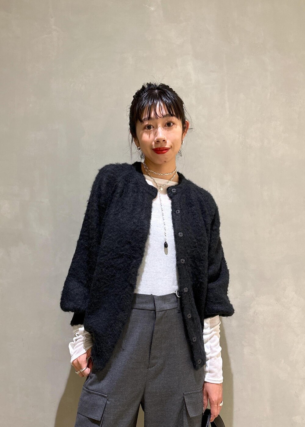 ブラック系のカーディガン/ボレロ、ブラック系のハンドバッグ、ホワイト系のTシャツ/カットソーを着用したレディースの秋コーディネートの6枚目の写真