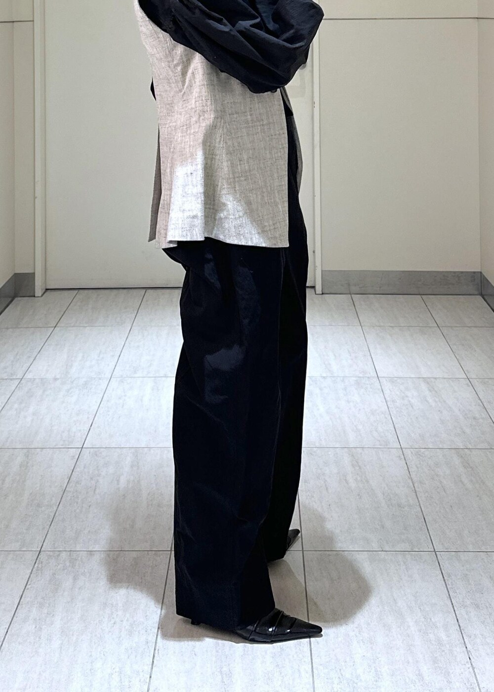 ホワイト系のハンドバッグ、ベージュ系のベスト、ブラック系のつなぎ/オールインワンを着用したレディースの冬コーディネートの9枚目の写真