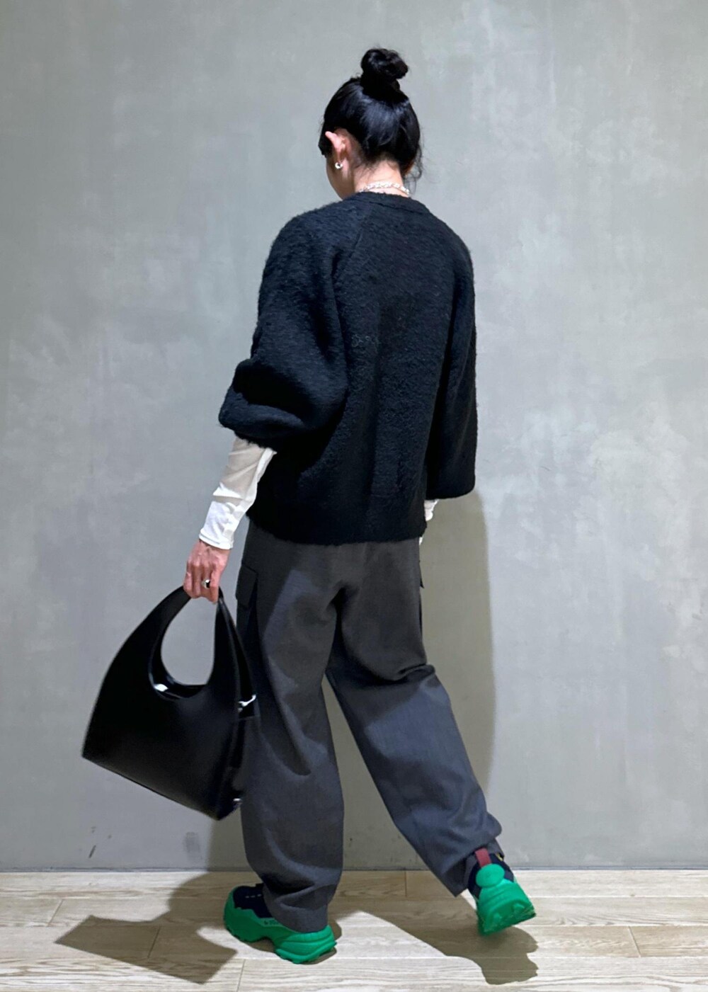 ブラック系のカーディガン/ボレロ、ブラック系のハンドバッグ、ホワイト系のTシャツ/カットソーを着用したレディースの秋コーディネートの5枚目の写真