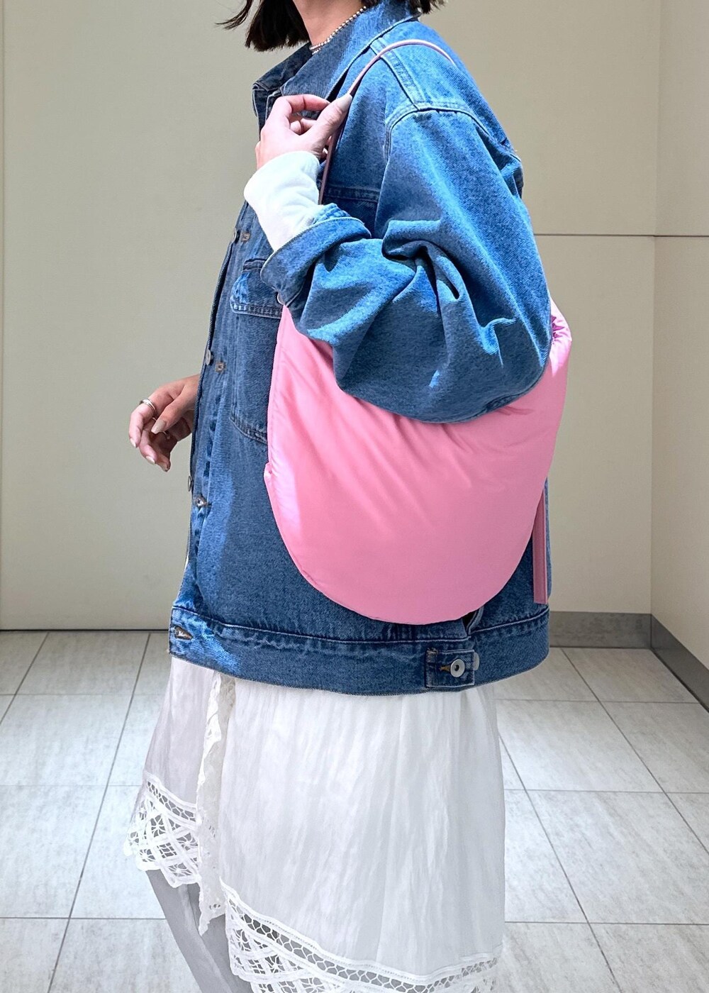 ホワイト系のその他パンツ、ピンク系のショルダーバッグ、ブルー系のデニムジャケットを着用したレディースの冬コーディネートの6枚目の写真