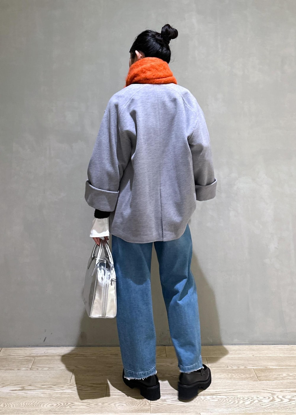 ホワイト系のTシャツ/カットソー、シルバー系のボストンバッグ、グレー系のその他アウターを着用したレディースの冬コーディネートの4枚目の写真