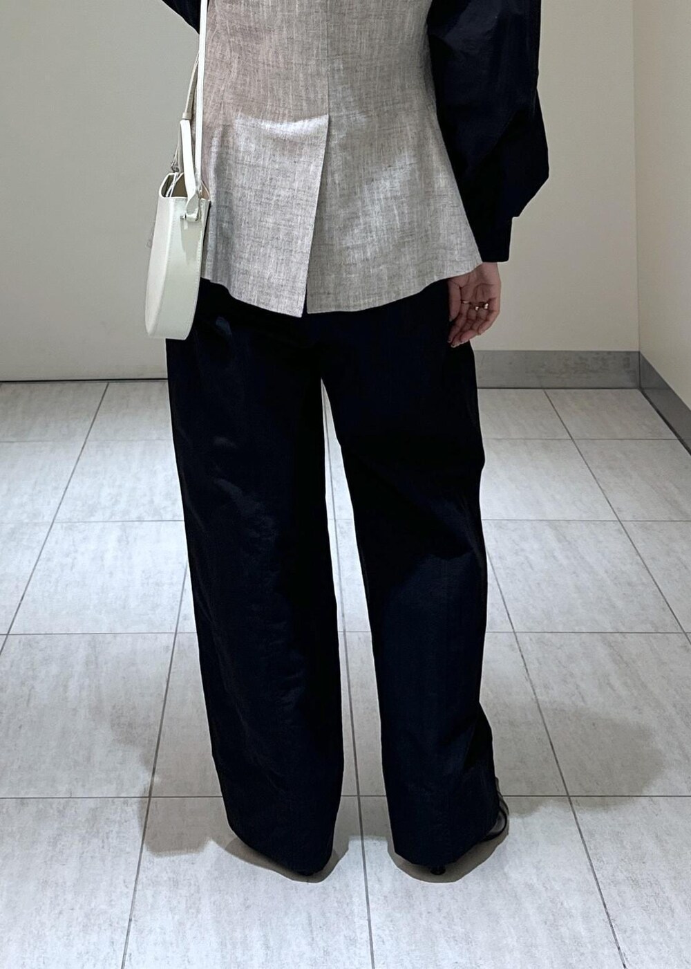 ホワイト系のハンドバッグ、ベージュ系のベスト、ブラック系のつなぎ/オールインワンを着用したレディースの冬コーディネートの10枚目の写真