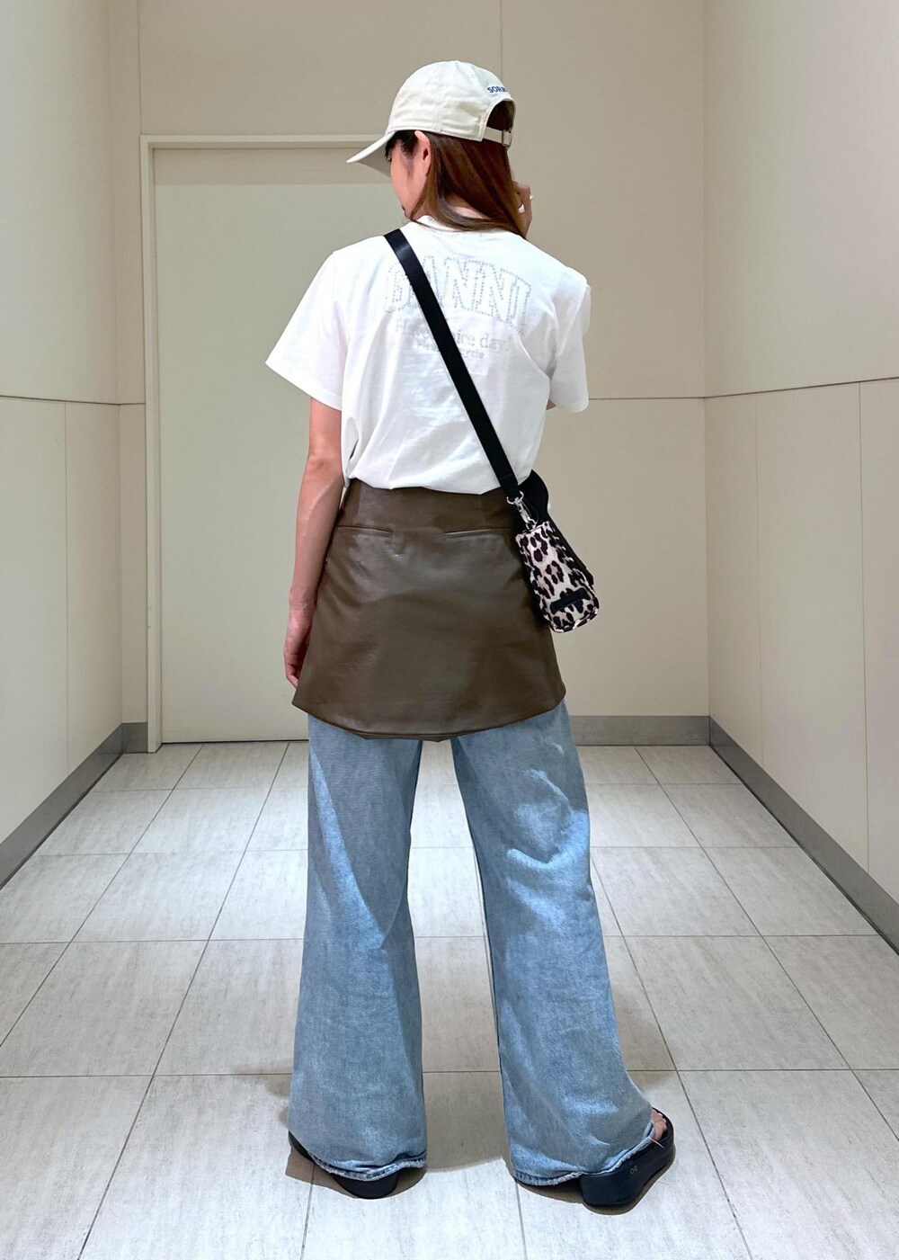 ベージュ系のトートバッグ、ブラウン系のスカート、ホワイト系のTシャツ/カットソーを着用したレディースの夏コーディネートの3枚目の写真