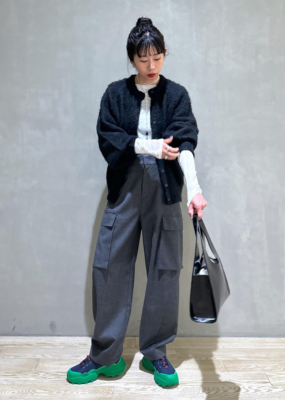 ブラック系のカーディガン/ボレロ、ブラック系のハンドバッグ、ホワイト系のTシャツ/カットソーを着用したレディースの秋コーディネートの3枚目の写真