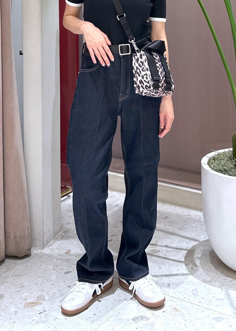 ブルー系のデニムパンツ、ベージュ系のショルダーバッグ、ホワイト系のスニーカーを着用したレディースの夏コーディネートの7枚目の写真