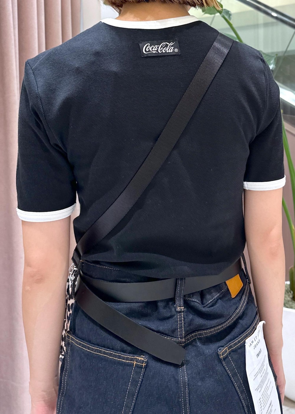 ブルー系のデニムパンツ、ベージュ系のショルダーバッグ、ホワイト系のスニーカーを着用したレディースの夏コーディネートの6枚目の写真